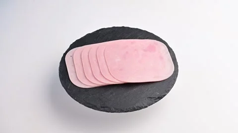 Sliced deli meat arranged neatly on a black slate plate Stock Footage 305231353