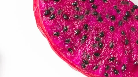 Sliced dragon fruit showcasing its vibrant pink skin and white flesh speckle Vídeos de archivo 313330262