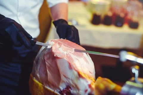 Sliced dried chamon prosciutto. A man cuts a jamon, a warm toned image. Selec Stock Photos