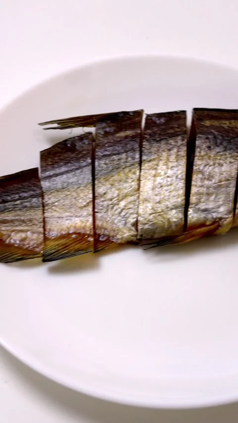 Sliced dried fish on a white plate displays unique food texture. Stock Footage 326185132