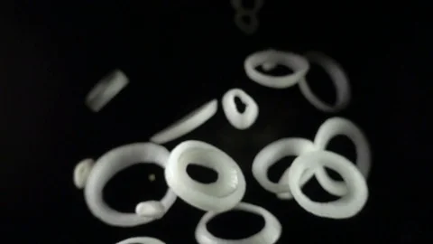 Sliced falling onion isolated on a black background Stock Footage 82856121