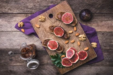 Sliced figs on bread with jam and nuts in rustic style Stock-Fotos
