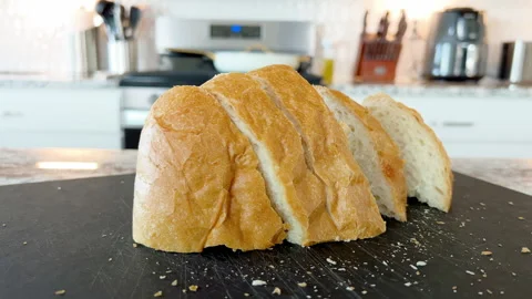 Sliced French bread on black cutting board Stock Footage 327855809