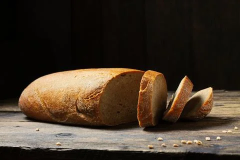 Sliced fresh bread loaf on rustic wooden table Stock Photos