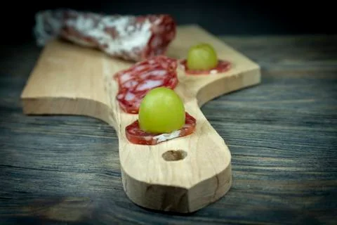 Sliced fresh green grape on slice Fuet sausage Stock Photos