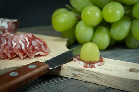 Sliced fresh green grape on slice Fuet sausage Stock Photos