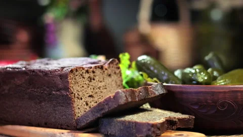 Sliced fresh homemade rye bread on wooden board salted cucumbers in bowl rustic Video stock 248235696