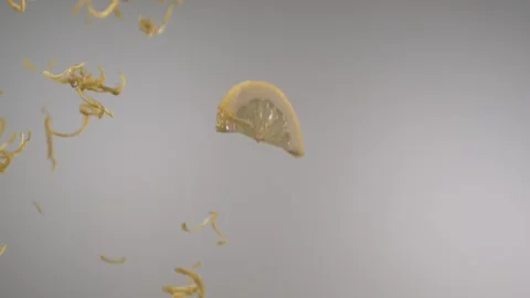 Sliced fresh lemons and lemon peels flying through in front of the camera Stock Footage 161526258