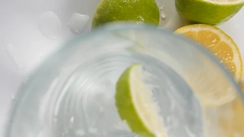 Sliced fresh lime citrus fruit from above in a drinking glass of water Stock Footage 88510962