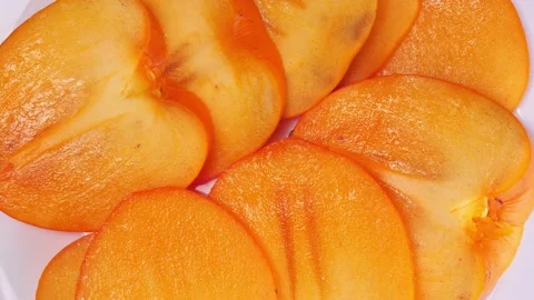 Sliced fresh persimmon close-up rotates Stock Footage 146936031