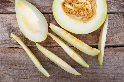 Sliced fresh sweet melon on a rustic wooden table. Top view Stock Photos
