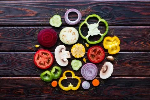 Sliced fresh vegetables in the form of a circle on the wooden background Stock Photos
