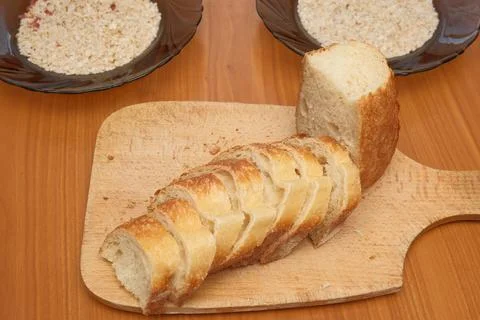 Sliced fresh white bread on an old wooden cutting board. Stock Photos