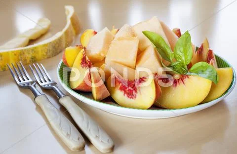 Sliced fruits peach melon Stock Photos