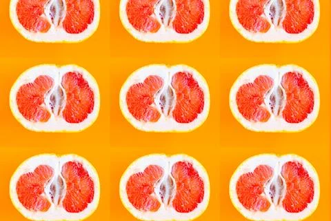 Sliced grapefruit pattern on bright orange background, minimal concept Stock Photos