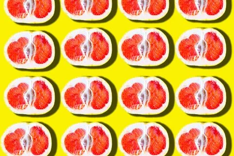 Sliced grapefruit pattern on bright yellow background, minimal concept Stock Photos