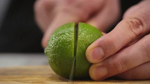 Sliced green lime. Slicing a lime with a knife. Cutting a lime in half. Vitamin Video stock 219564399