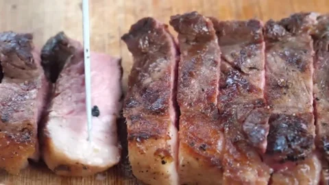 Sliced Grilled BBQ Beef Steak on Wooden Board Close-up Stock Footage 338210720