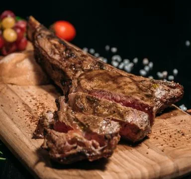 Sliced ​​grilled Tomahawk beef steak on a board Stock Photos