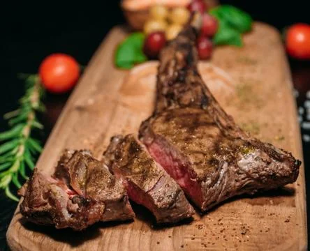 Sliced ​​grilled Tomahawk beef steak on a board Stock Photos