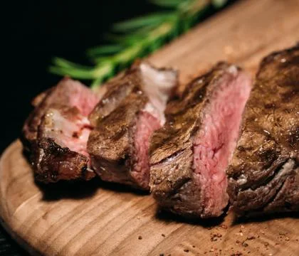 Sliced ​​grilled Tomahawk beef steak on a board, close-up Stock Photos