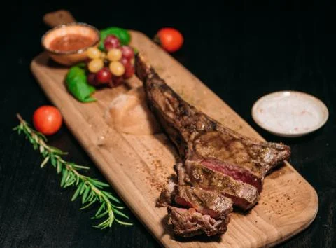 Sliced ​​grilled Tomahawk beef steak on a board Stock Photos