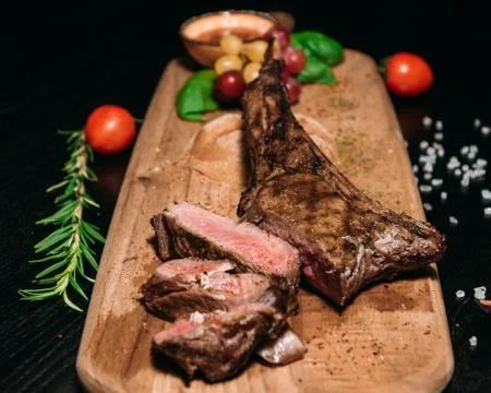 Sliced ​​grilled Tomahawk beef steak on a board Stock Photos