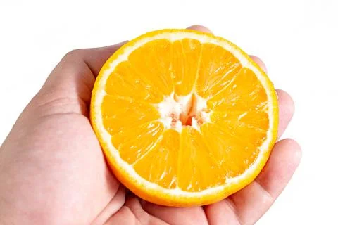 Sliced Half Orange fruit in the hand above white background Stock-Fotos