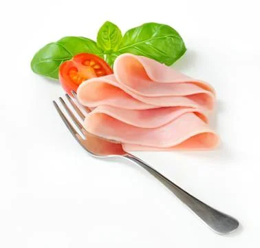 Sliced ham on fork with fresh tomato and basil Stock Photos