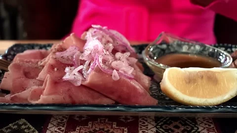 Sliced ham with onion topping on decorative plate beside dipping sauce and Video stock 343628431