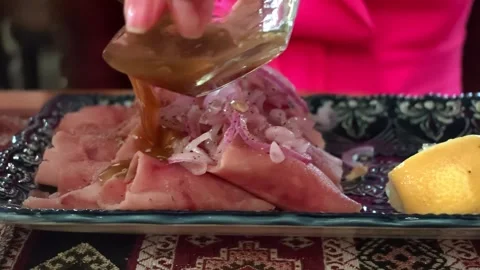 Sliced ham with onion topping on decorative plate beside dipping sauce and Video stock 343628472