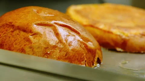 Sliced hamburger bun sizzles gently in hot oil on pan Video stock 324922477