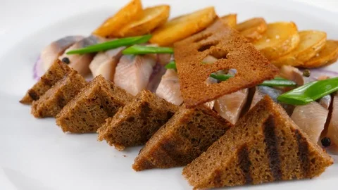 Sliced herring, decorated with roast potato, onion and crispy toasts Stock Footage 84263080