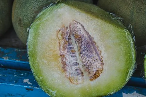 Sliced Honeydew Melon Wrapped in Plastic Film Foto stock