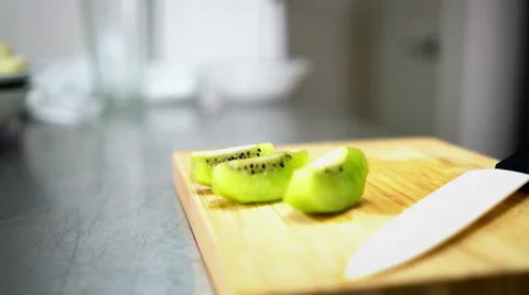 Sliced Kiwi on Cutting Board with Ceramic White Knife - 4K Resolution Stock Footage 59785501