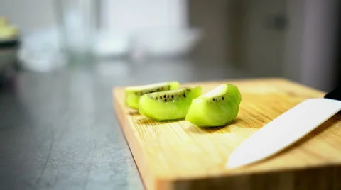 Sliced Kiwi on Cutting Board with Ceramic White Knife 60 fps Stock Footage 59785551