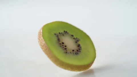 Sliced kiwi falling and spinning. Slow Motion. Stock Footage 79478845
