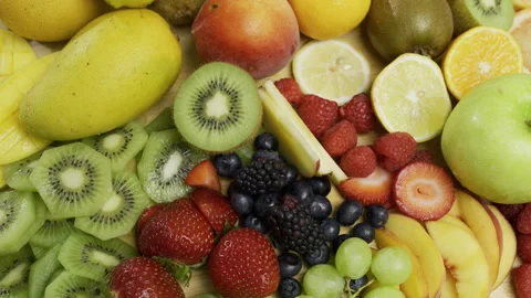 Sliced up kiwi, lemons, oranges and peaches with various other fruits in Stock Footage 341215428