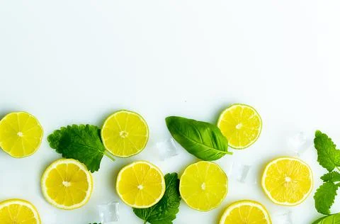 Sliced lemon with mint and ice white surface top view Stock Photos