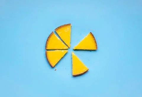 Sliced lemon pie on blue background. Fruit tart slices Stock Photos