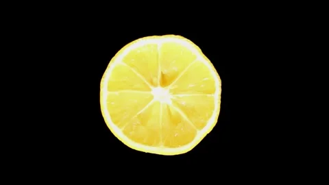A sliced lemon rotates on a black background. Citrus fresh lemon fruit. Stock Footage 242522585