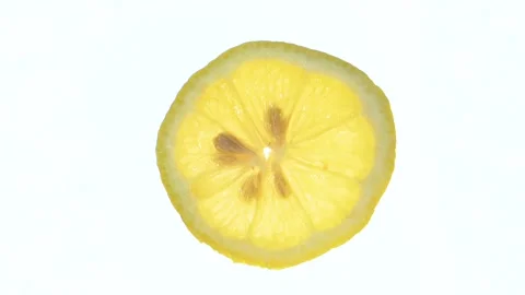 Sliced lemon spinning on white background Video stock 285004111