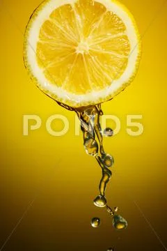 Sliced lemon with a water dropping from it Stock Photos