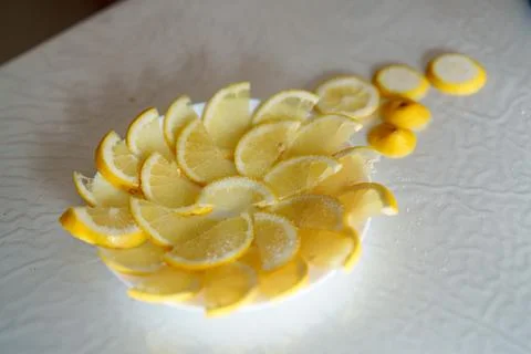 Sliced lemons arranged in a circular pattern on a white surface for a refre.. Stock Photos