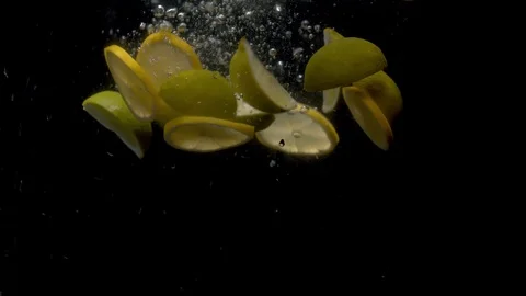 Sliced lemons falling into the water Stock Footage 123579295