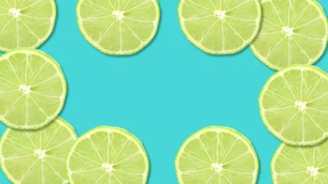 Sliced lime fruit on blue background with stop motion effect. Seamless loop.. Stock Footage 235909020