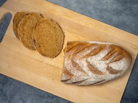Sliced loaf of black bread on a kitchen board. Bread on a black background. H Foto stock