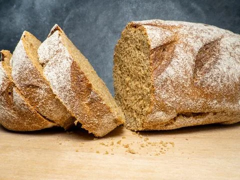 Sliced loaf of black bread on a kitchen board. Bread on a black background... Foto stock