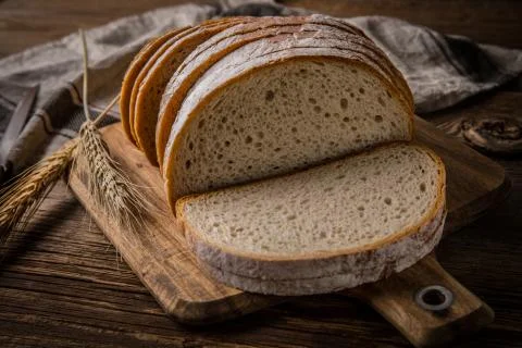 Sliced loaf of bread on a chopping board. Stock Photos
