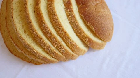 Sliced loaf of bread slowly rotating on white Video stock 47789727